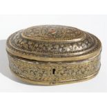 An Indian oval brass box decorated with foliate scrolls, 178cms (6.75ins) wide.