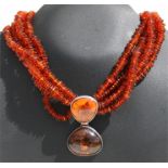 A Baltic amber necklace with silver mounted amber pendant.