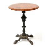 A circular mahogany topped pub table, standing on a cast iron base, 58cms (22.75ins) diameter.
