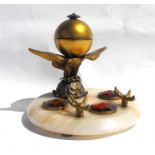 A brass inkwell surmounted on an eagle with outswept wings, mounted on a figured onyx base, 18cms (