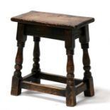 An oak joint stool, on turned legs joined by stretchers, 46cms (18ins) wide.