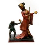 A large Japanese bronze group depicting a robed lady playing a drum with a monkey holding a fan,