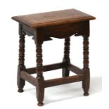 An oak joint stool on turned legs joined by stretchers, 46cms (18ins) wide. 26cm (10.5ins) deep 52cm