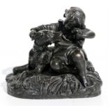A 19th century bronze group depicting a child sat with a dog and puppies, 14cms (5.5ins) high.