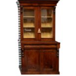 A Victorian mahogany bookcase on cupboard, the pair of glazed doors enclosing a shelved interior,
