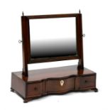 An early 19th century mahogany toilet mirror, the shaped front with three short drawers, standing on