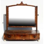 A 19th century mahogany toilet mirror with three frieze drawers, standing on turned ivory feet,