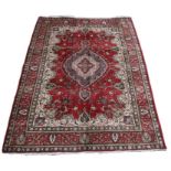 A Tabriz carpet with central medallion on a red ground 325 by 245cm