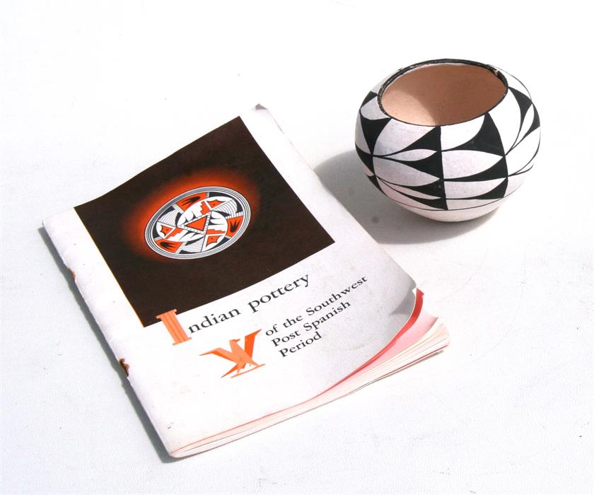 A South American Indian pottery pot, 7cms (2.25ins) high; together with an Indian pottery book.