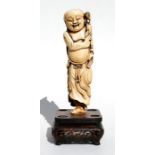 A 19th century Chinese ivory carving in the form of Liu Hai, standing on one leg with his toad