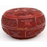A large Chinese cinnabar lacquer box and cover, of circular compressed form, decorated with