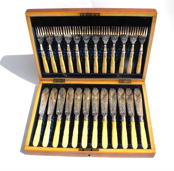 A cased set of twelve silver plated fish eaters with silver collars and ivory handles.