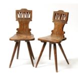 A pair of continental walnut and elm hall chairs, on reeded tapering legs.