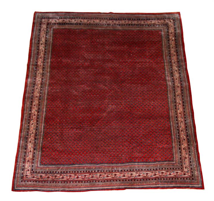 A Persian Sarouk carpet with a repeat design within geometric borders, on red ground, 360 by