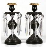 A pair of bronze candlesticks with cut glass lustres, 21cm (8.25ins) high.