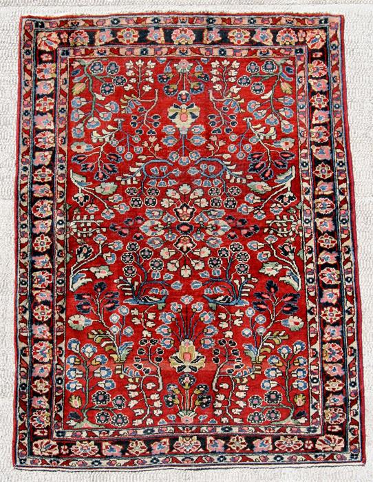 A Persian Mahal carpet with mirrored foliate design on a red ground, 200 by 130cms (79 by 51ins).