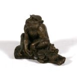 A bronze figure, in the form of a monkey sat on a log, 7cm (2.75ins) high