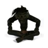 A carved wooded figure, in the form of a grotesque seated man, 46cm (18ins) high.