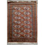 A Caucasian rug with repeated geometric design on a red ground. 126 by 202cm (49.5 by 79.5ins)