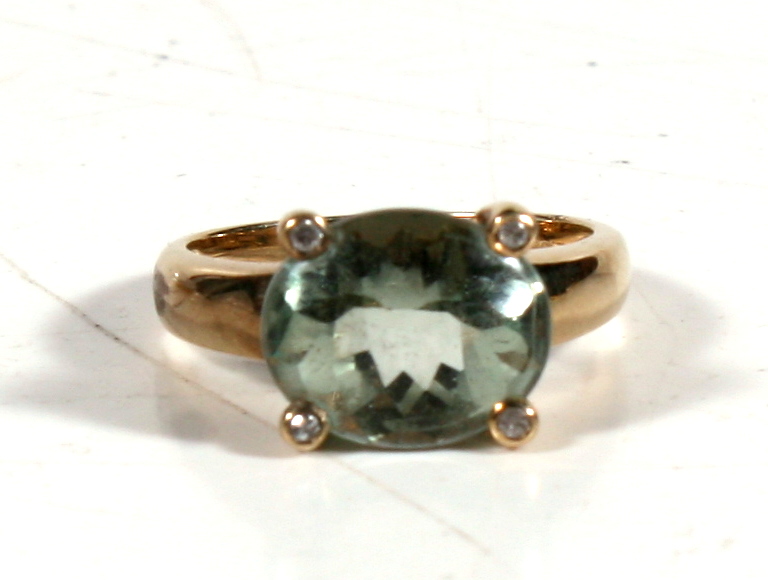 A 9ct gold ring set with a large central aquamarine and four small diamonds, approx UK size N.