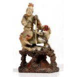 A Chinese carved soapstone group depicting a figure on horseback, 13cm (5ins) high.