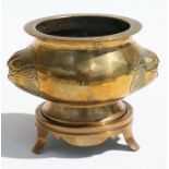 A polished bronze censer on stand with mythical beast mask handles, 10cms (4ins) high.