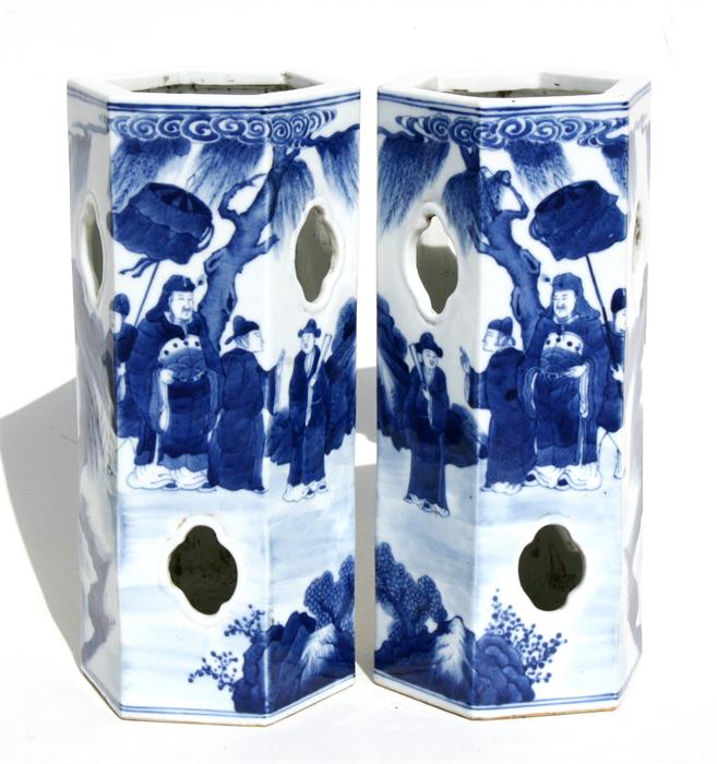 A pair of Chinese hexagonal form blue & white wig stands decorated with figures in a landscape, with