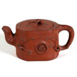 A Chinese Yixing pottery teapot decorated with prunus, impressed seal mark to the underside, 9cm (
