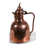 A Turkish copper coffee pot decorated with foliate scrolls and calligraphy, 28cm (11ins) high.