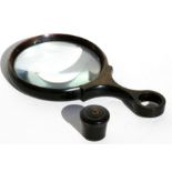 A rhino horn magnifying glass, 15cms (6ins) long; together with a rhino horn miniature lidded pot,