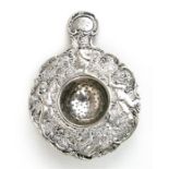 A continental white metal tea strainer decorated in relief with cherubs, 10cms (4ins) diameter.