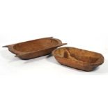 Two carved wooden dough troughs, the largest 61cms (24ins) wide.