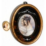 An oval portrait miniature depicting two young ladies reading a book, indistinctly signed, mounted