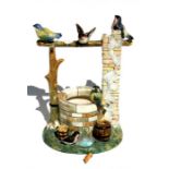 A Delphin Massier ceramic model of a wishing well, decorated with applied birds, 36cms (14ins)