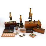 A lacquered brass microscope in a walnut box; two student microscopes; another microscope and a