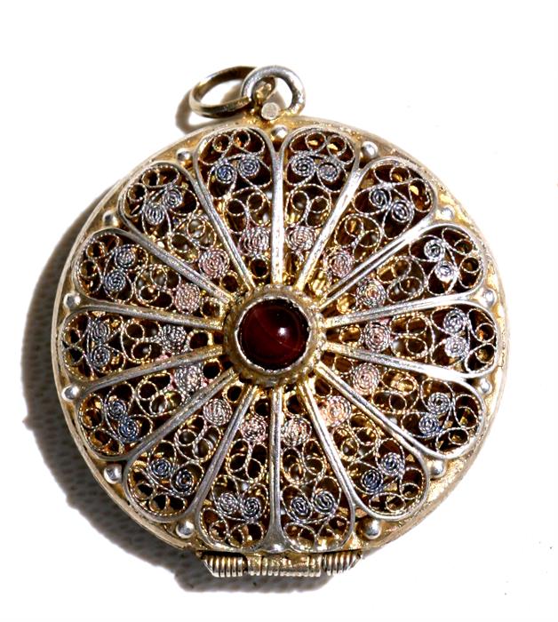 A silver gilt filigree locket set with an agate cabochon, 2.5cms (1ins) diameter.