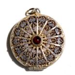 A silver gilt filigree locket set with an agate cabochon, 2.5cms (1ins) diameter.