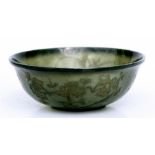 A Chinese spinach jade bowl decorated with prunus & calligraphy, with four-character seal mark to