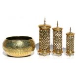 A set of three graduated pierced brass candle holders, the largest 32cms (12.5ins) high; together