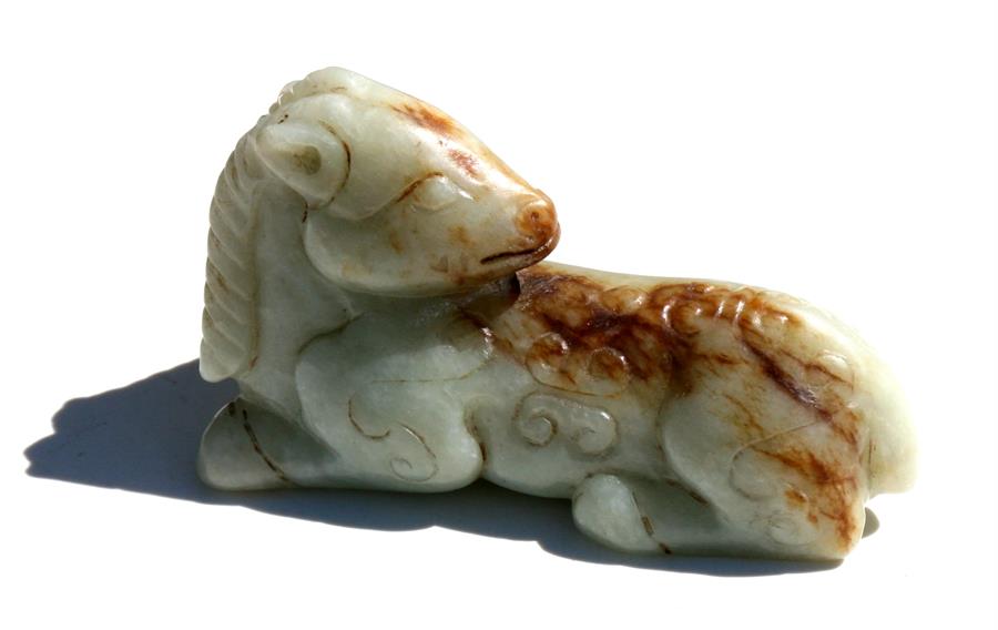 A Chinese mutton jade figure in the form of a recumbent horse, 7.5cms (3ins) long. Condition