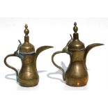 Two Turkish / Islamic dallah coffee pots with impressed mark to bodies, the largest 31cms (12.