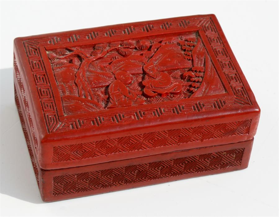 A 19th century Chinese cinnabar lacquer box decorated with seated figures in a garden, 9.7cms (3.