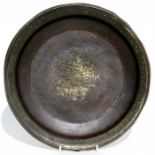 An Islamic bronze bowl with central star motif within a foliate border, the remains of gilding,