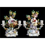 A pair of 19th century Chelsea style porcelain figural candlesticks, modelled as a young man and a