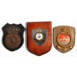 A copper ships crest or plaque mounted on a wooden shield to the WWII Battleship HMS Howe with two