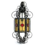 A wrought iron and coloured glass hall lantern, 65cms (25.5ins) high.