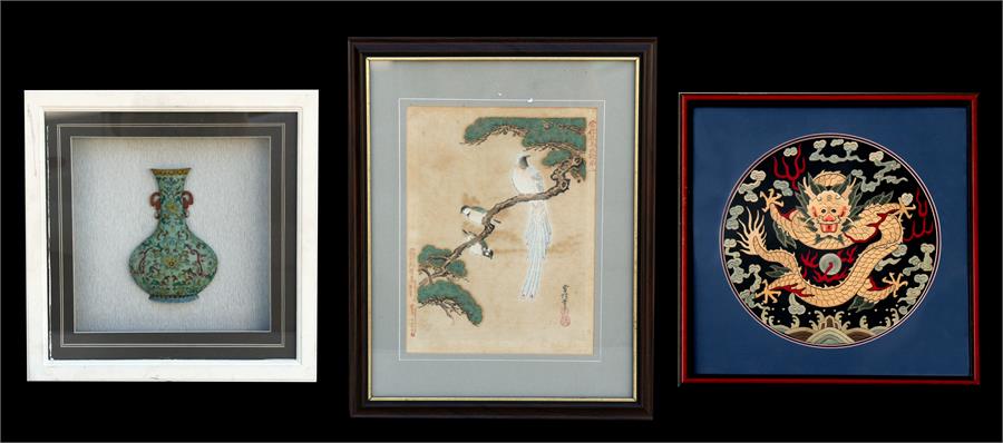 A Chinese circular silk embroidered panel depicting a dragon chasing a flaming pearl, framed &