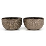 A pair of Indian / Burmese white metal bowls decorated with figures & foliage, stamped '70' to