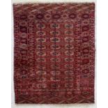 A Persian rug with a repeated gul design within a geometric border, on red ground, 123 by 188cms (