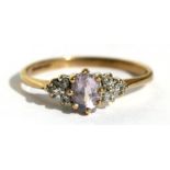 A 9ct gold ring set with a central oval pale amethyst and flanked by six diamonds, approx UK size '